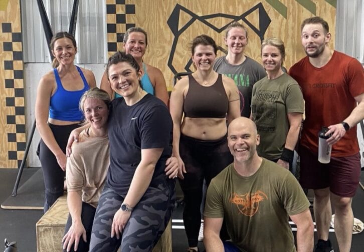 Coach supporting member during group workout at 321 Wellness showing why motivation doesn’t work alone